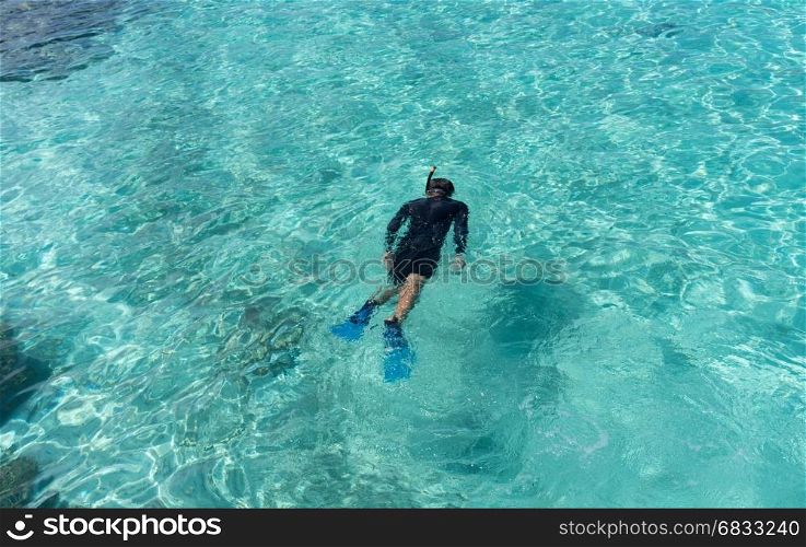 Young woman snorkeling in tropical water on vacation