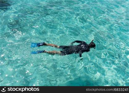 Young woman snorkeling in tropical water on vacation