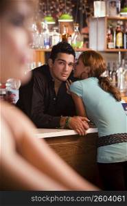 Young woman socializing with bartender, night