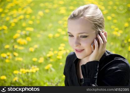 Young Woman Speaking By Phone On The Meadow