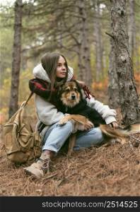 young woman spending time together with her dog forest