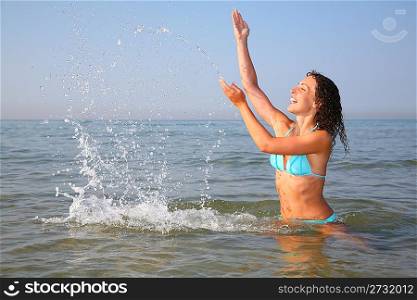 Young woman splashing in sea