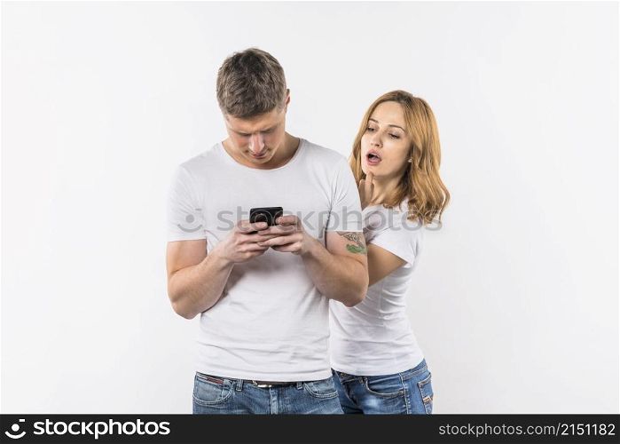 young woman spying her boyfriend s phone against white background