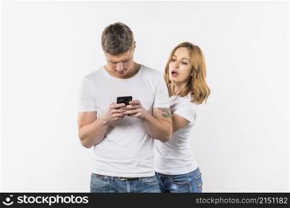 young woman spying her boyfriend s phone against white background