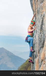 Young woman stairs a wall during a rock course First rope