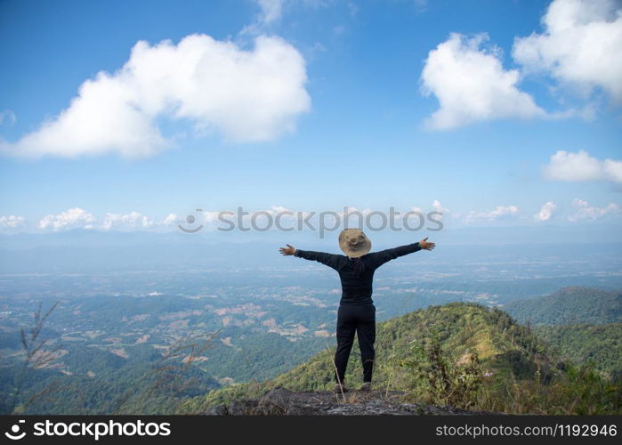 young woman stand on top mountain, view point with blue sky at sunny day. soft focus.