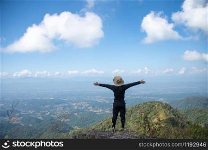 young woman stand on top mountain, view point with blue sky at sunny day. soft focus.