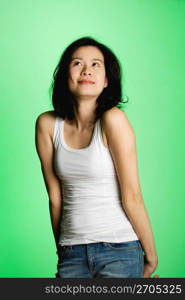 Young woman standing against green background