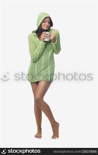 Young woman standing and holding a cup of coffee