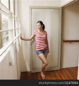 Young woman standing at a doorway and smiling