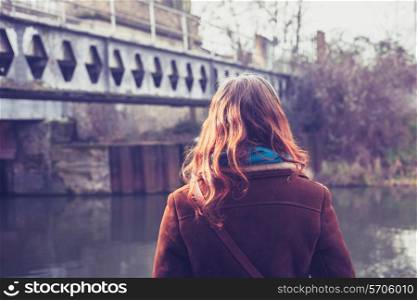 Young woman standing by a canal