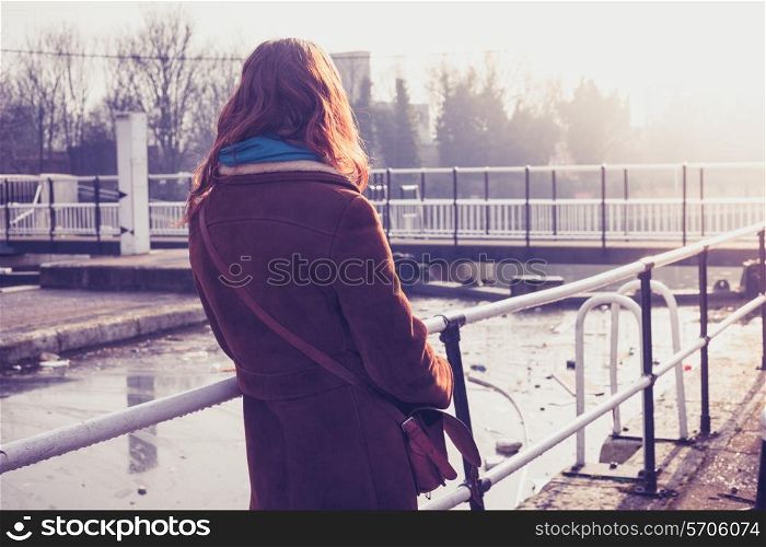 Young woman standing by a canal