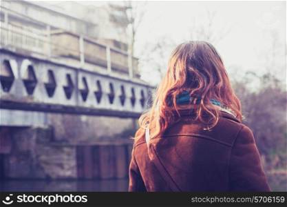 young woman standing by a canal