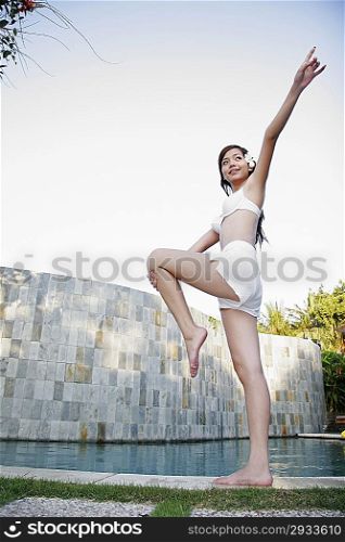 Young woman standing by swimming pool