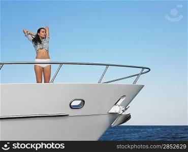 Young woman standing in bow of yacht