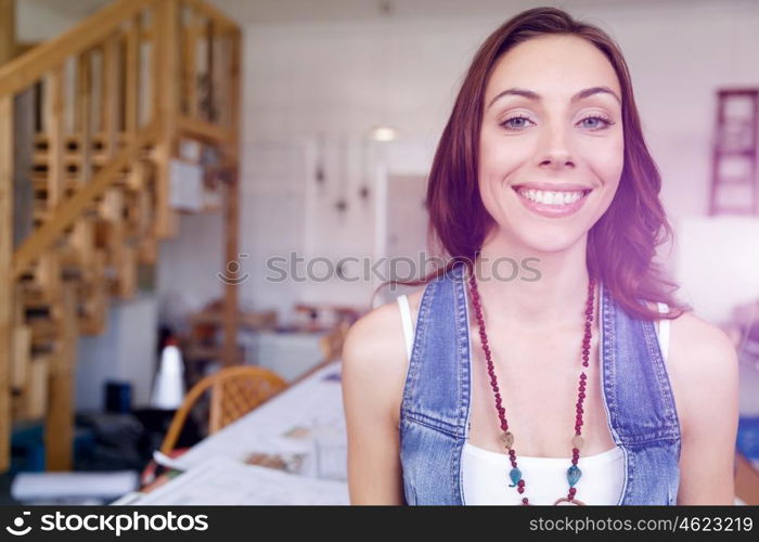 Young woman standing in creative office. Smiling young designer standing in creative office