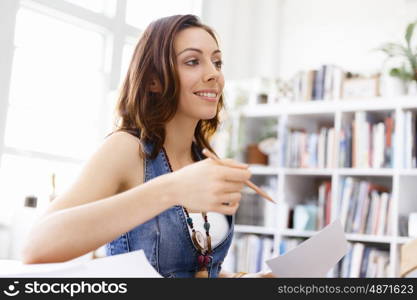 Young woman standing in creative office. Smiling young designer standing in creative office