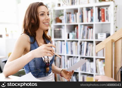 Young woman standing in creative office. Smiling young designer standing in creative office