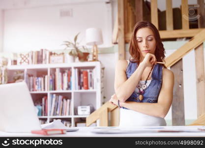 Young woman standing in creative office. Smiling young designer standing in creative office