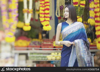 Young woman standing in front of a garland shop