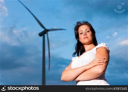 Young woman standing in front of windmill and the blue sky