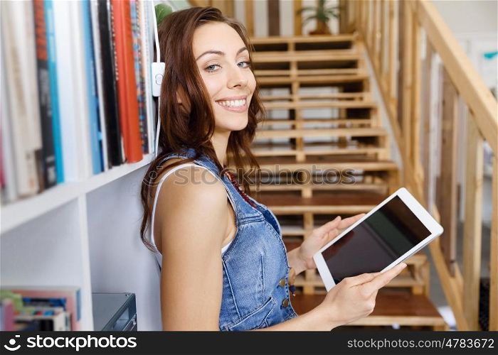Young woman standing in office with notepad. Smiling young designer standing in office and holding notepad