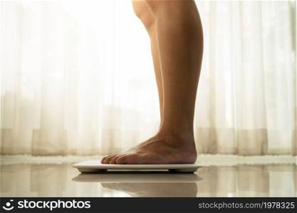 young woman standing on digital weight scale