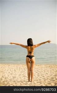 Young woman standing on the beach in a bikini