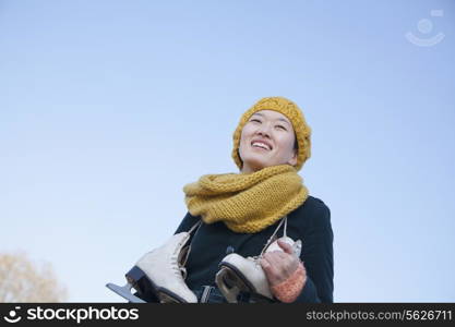 Young Woman Standing with Ice Skates