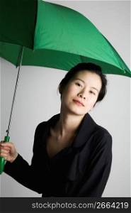 Young woman standing with umbrella, portrait