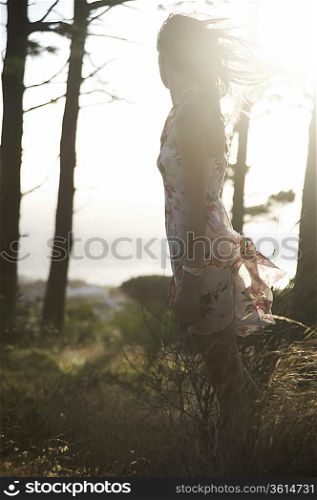 Young woman stands in summer woodland