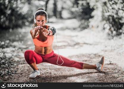 Young woman stratching after jogging in the park