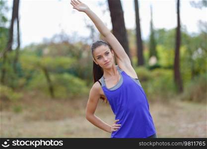 young woman stretching arms outdoors