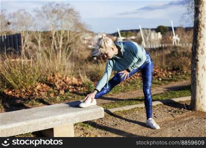 Young woman stretching during a jog on waterfront