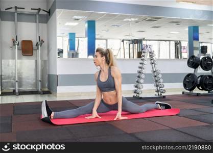 young woman stretching exercising indoors in fitness club. young woman stretching exercising in fitness club