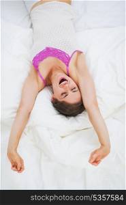 Young woman stretching in bed after sleep