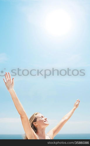 Young woman stretching in front of sea, side view