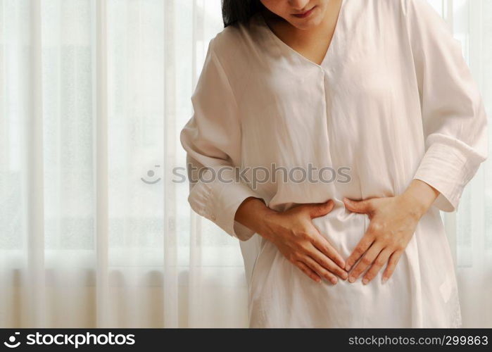 Young woman suffering from abdominal pain feeling stomachache, symptom of pms on white background