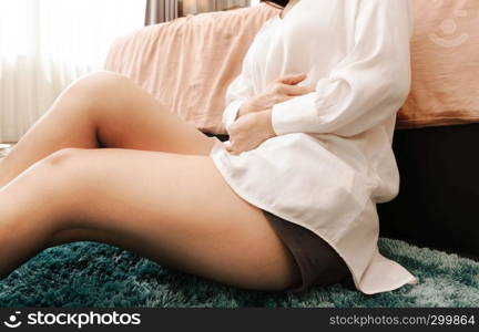 Young woman suffering from abdominal pain feeling stomachache, symptom of pms on white background