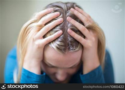 Young Woman Suffering From Depression With Head In Hands