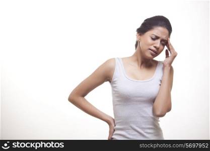 Young woman suffering from headache against white background