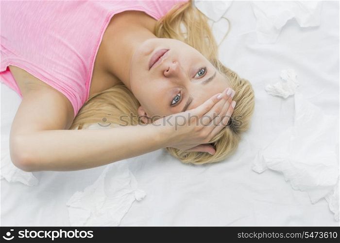 Young woman suffering from headache while lying on bed