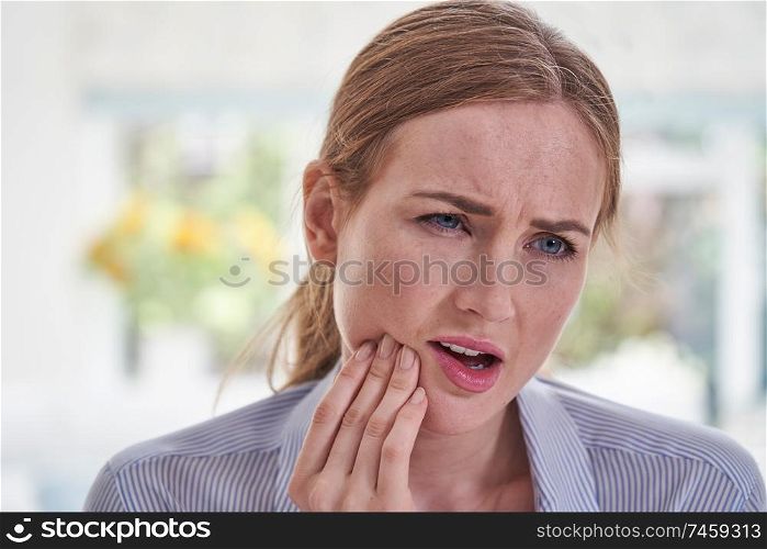 Young Woman Suffering With Toothache Touching Jaw