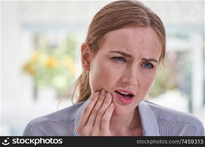 Young Woman Suffering With Toothache Touching Jaw