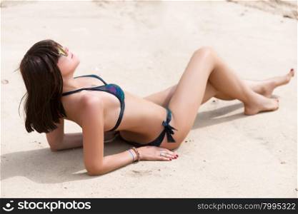 young woman sunbathing on a sandy beach