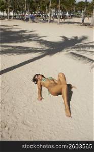 Young woman sunbathing on the sand