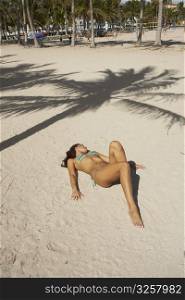 Young woman sunbathing on the sand