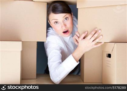 Young woman surrounded by carboard boxes