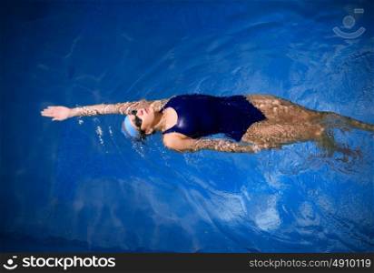 Young woman swimmer in blue pool