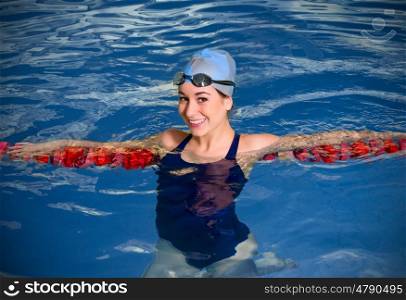 Young woman swimmer in blue pool water